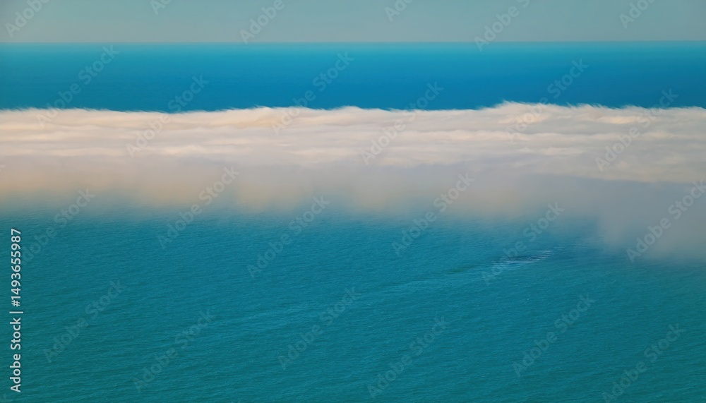 Aufkleber aerial view of ocean surface blending into low coastal fog under clear blue sky for web design, natu