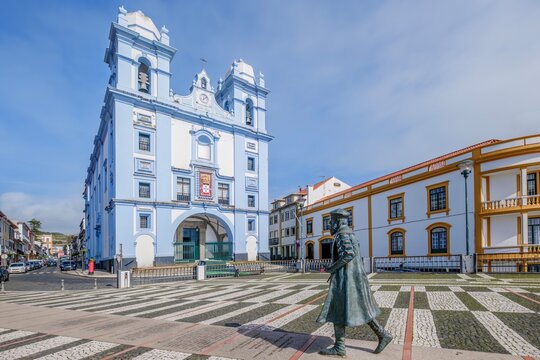 The striking blue and white facade of the Church of Mercy (Igreja da Misericordia) stands prominently in Angra do Heroismo, Terceira, Azores. Statue of an explorer Vasco de Gama graces the foreground