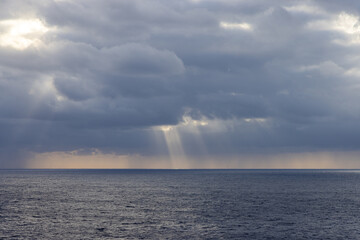 Dramatic Cloudscape Over the Expansive Pacific Ocean with Sun Rays Peeking Through