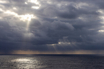 Obraz premium Dramatic Cloudscape Over The Pacific Ocean With Sun Rays Shining Through Clouds