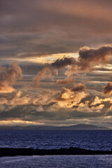 Over the deep waters of Lake Titicaca, stormy clouds and golden light collide in a breathtaking display