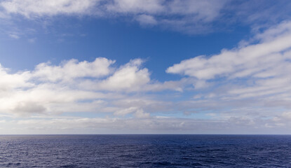 Obraz premium Expansive View of Ocean Horizon with Cloudscape and Vibrant Blue Sky