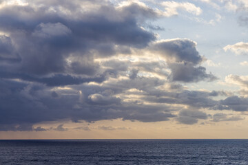 Dramatic Cloudscape Over Calm Pacific Ocean During Tranquil Sunset