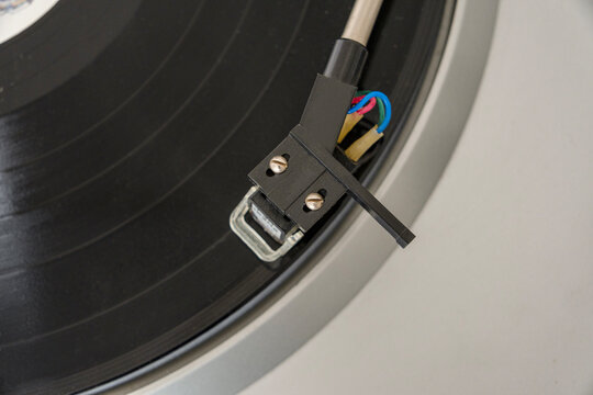 pickup stands on vinyl record, close-up, copy space