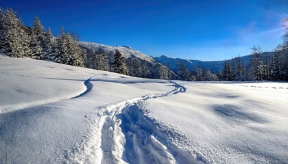 pristine snow trail winding through sunlit alpine landscape under deep blue sky with distant mountains for winter web design, travel poster, print decor, or seasonal branding

