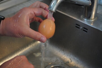 someone is washing an egg under water