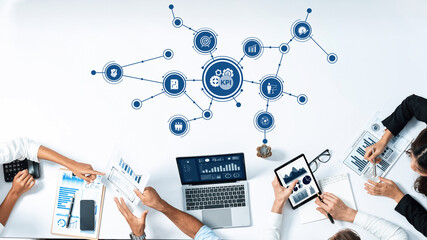 This image depicts a collaborative business strategy meeting focused on key performance indicators. Participants are using modern tools for data analysis and insights. Amity © InfiniteFlow