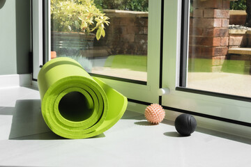 Yoga home studio concept. Green yoga mat and balls prepared to start new day 