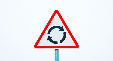 A triangular road sign with a red border and black arrows indicating a roundabout ahead on a white background