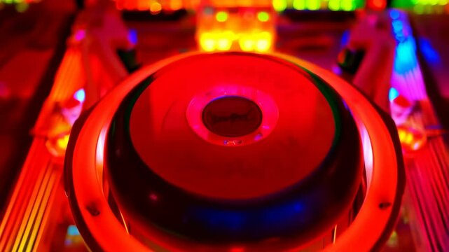 Illuminated pinball machine surface with vibrant neon colors, bumpers, lights and playfield elements, creating a retro amusement arcade scene.
