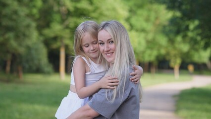 Obraz premium A beautiful joyful and happy mother with a small child in her arms summer portrait