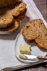 Homemade artisan bread with butter on a light background.