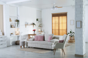 Comfortable sofa with cushions in room. Interior design