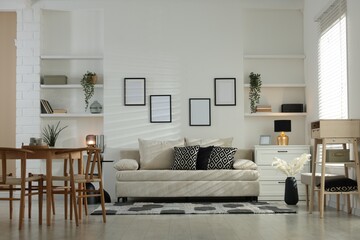 Comfortable sofa, table, chairs and dresser indoors. Interior design