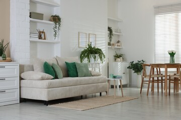 Comfortable sofa, table, chairs and green houseplants indoors. Interior design