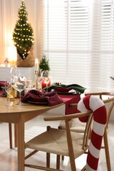 Christmas table setting with stylish dishware and festive decor indoors