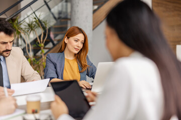 Selective focus on a businesswoman typing on a laptop during the meeting.