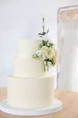 Delicious wedding cake with floral decor on wooden table indoors
