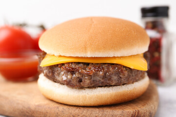 Cheeseburger with tasty patty on white table, closeup