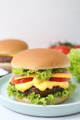 Tasty cheeseburger on white table, closeup. Space for text