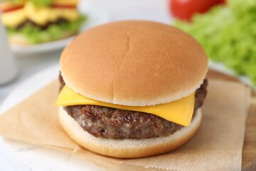 Cheeseburger with tasty patty on white table, closeup
