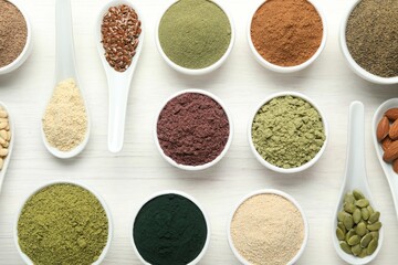 Different superfood powders on white wooden table, flat lay