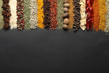 Many different spices on black table, flat lay. Space for text
