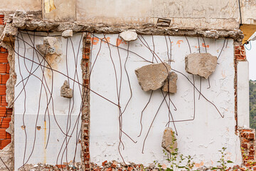 Rusty rebars and concrete fragments are visible on a partially demolished building with exposed...