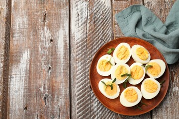 Hard boiled eggs with microgreens on wooden table, top view. Space for text