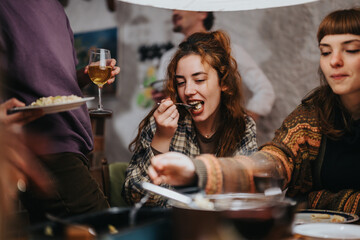 A cheerful gathering of friends sharing food and drinks, enjoying a lively and cozy moment indoors. The image captures the joy and warmth of friendship and shared experiences.
