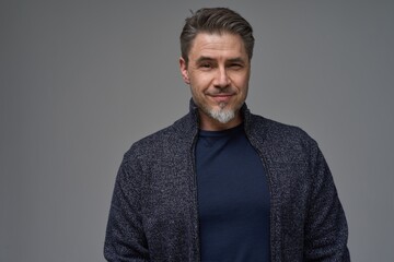 Middle age casual man in t-shirt. Mid adult, mature age man, happy smiling. Isolated on gray, copy space  ..