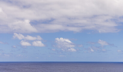 Fototapeta premium Serene Ocean Horizon With Soft Clouds in a Clear Blue Sky