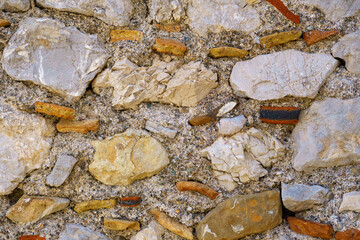 abstract detail of a stonewall pattern with different kind of stones and bricks from a typical sicilian medieval castle 