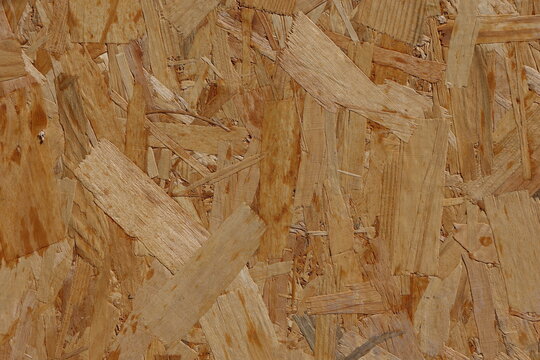 Background with recycled natural wood texture with warm tones showcasing organic patterns of oriented strand board for sustainable design