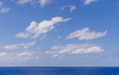 Obraz premium Tranquil Blue Ocean with Stunning Cloudscape Under a Bright Sky