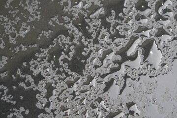 Dark grey surface with water or rain drops close up