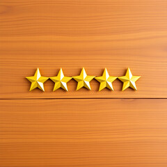 five golden stars in a line on a wooden table, concept of five stars review or service, space for copy