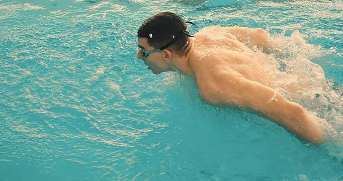 Swimmer Gliding Through the Pool. Focused and powerful strokes, clear blue water. Sports, determination and endurance. Competitions.	