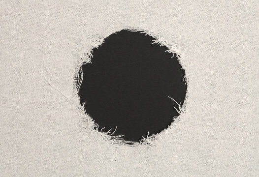 Grunge beige canvas denim fabric torn circle frame. Texture abstract background.