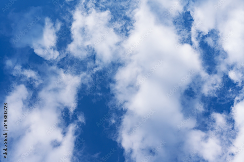 Wall mural bottom view of the blue summer sky with white clouds, copy space, abstract background