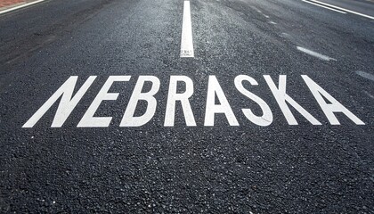 Nebraska road marking on asphalt highway with white arrow indicating direction