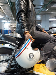 close up of biker in brown leather gloves holding white helmet