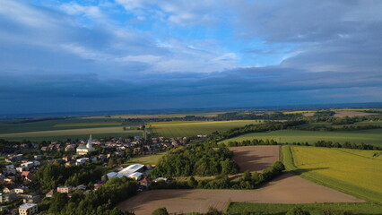 Beautiful Spring Panorama of Hněvo&scaron;ice Village with Blooming Rapeseed and Dramatic Sky