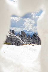 Dolomites in South tyrol, alto adige, photographed through a hole in a pile of snow creating a...