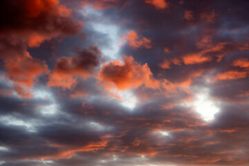 The photo shows a dramatic sky with bright orange-red clouds illuminated by the sunset