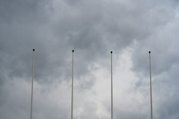 Flagless flagpole against cloudy grey sky symbolizing absence void uncertainty national identity change concept tall empty pole minimalist
