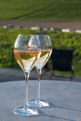 Glasses of white sparkling wine brut, grand reserve, champagne on green hilly vineyards in old wine making grand cru Ay-Champagne village in Vallee de la Marne, Champagne, France