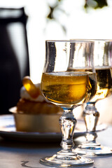 French cuisine, fresh baked baba au rum cake with chantilly cream, sweet dessert with rum and glasses of champagne wine close up