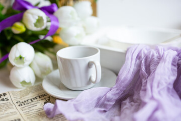a cup of tea with cakes and a bouquet of flowers on the table
