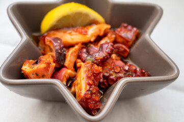 Tasty antipasti salad or starter seafood dish, grilled octopus spanish style with red paprika  served in restaurant